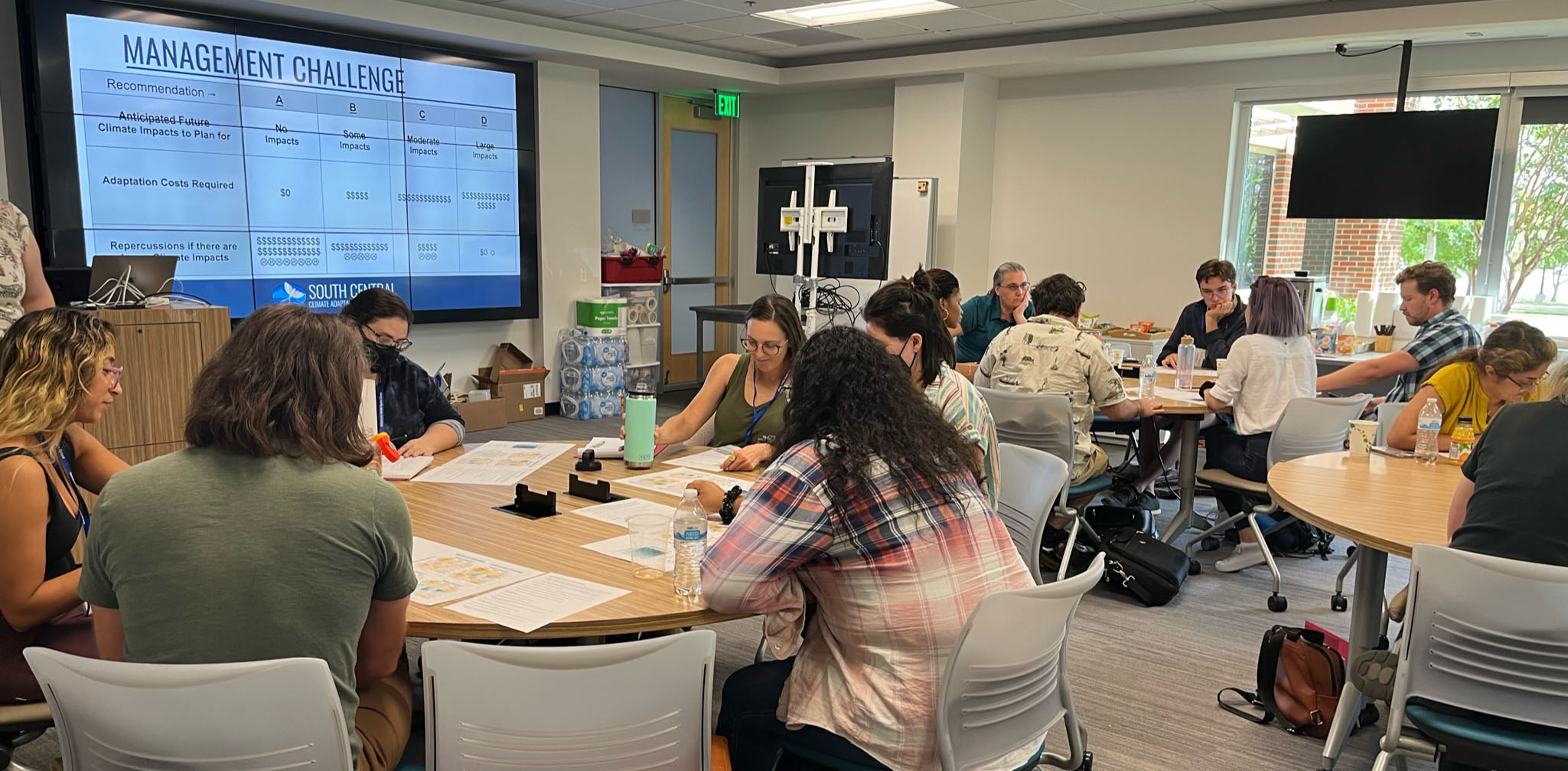 A group of workshop attendees working on a project at different tables