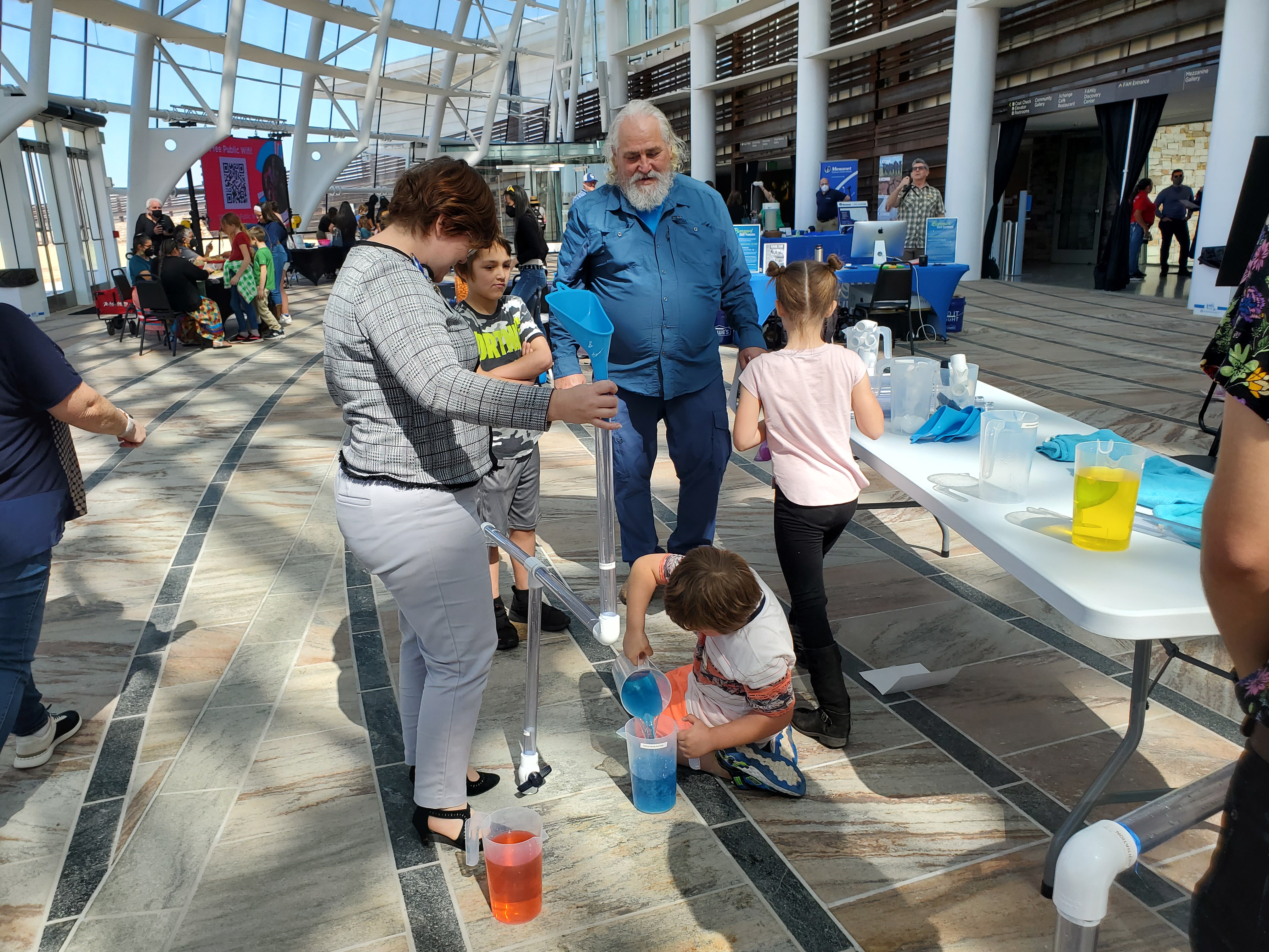 A group of people build a rain water harvesting pipeline at an event