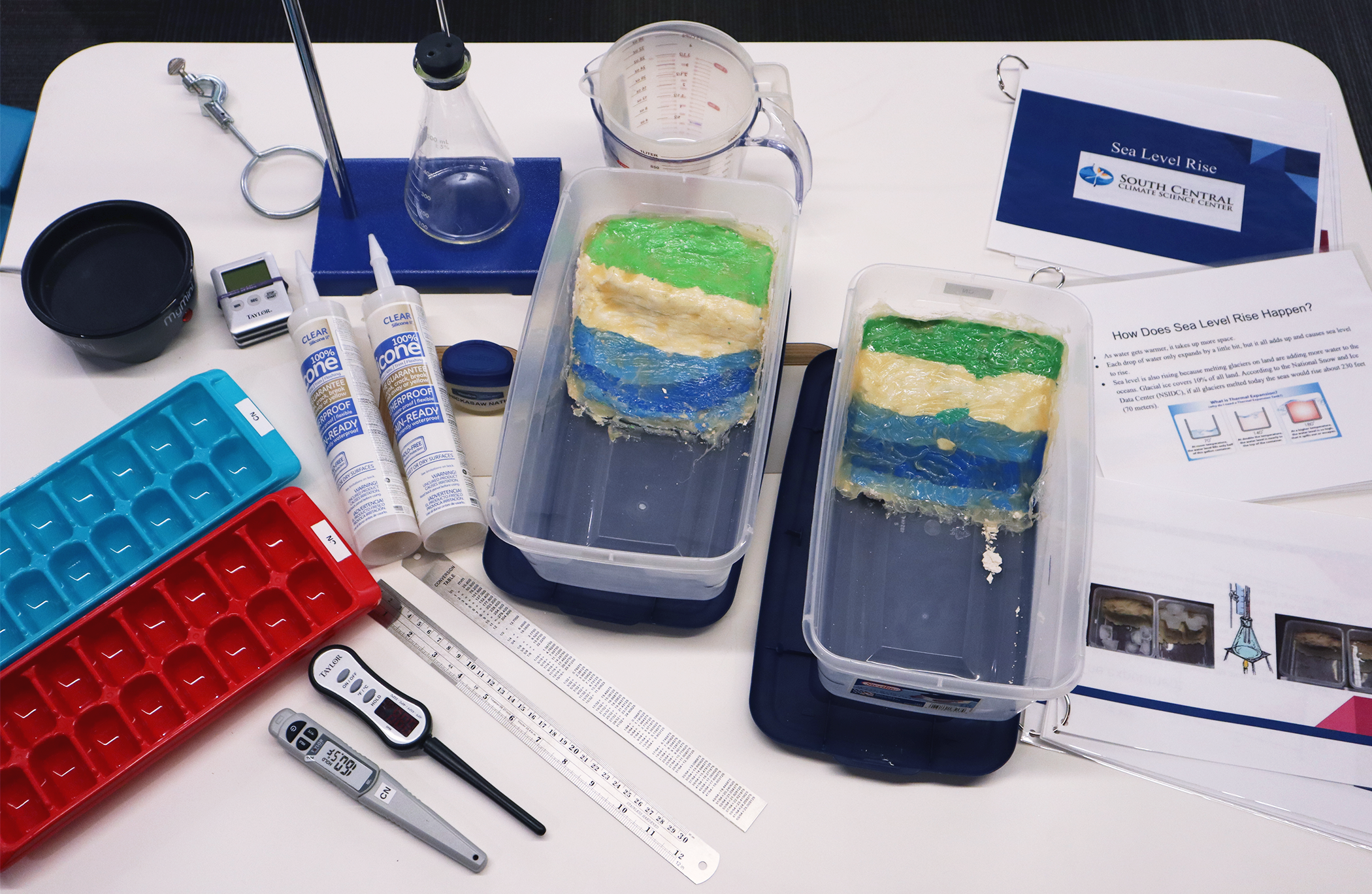 A spread of items from this activity kit, including thermometers, rulers, ice cube trays and more.