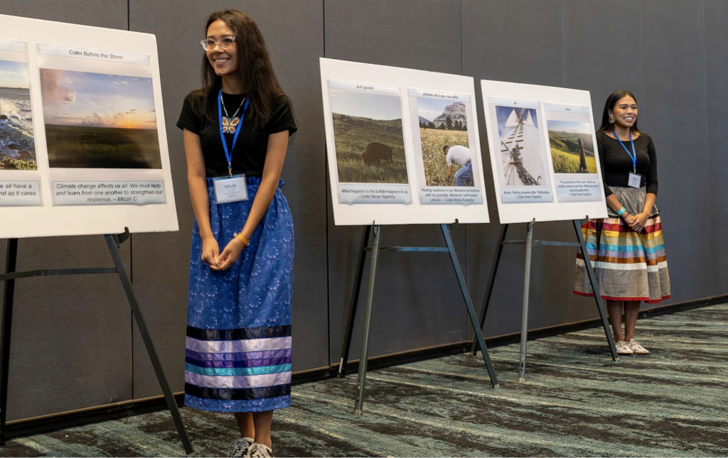 Two participants standing next to their Photo Voice presentations